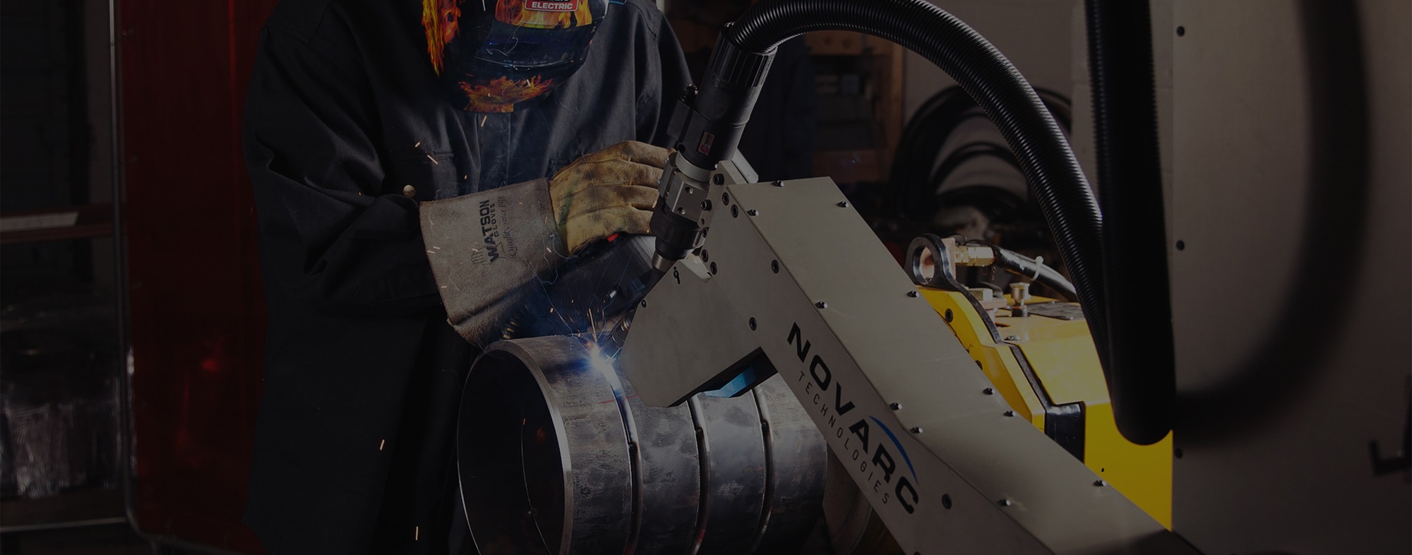 A welder working with a Novarc robotic welding machine